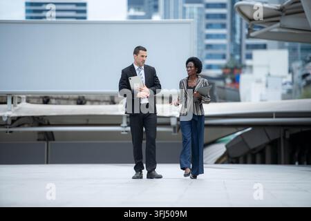 Diverses professionnels d'affaires discutant du travail et examinant des informations sur des tablettes Banque D'Images