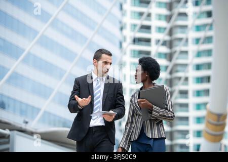 Diverses professionnels d'affaires discutant du travail et examinant des informations sur des tablettes Banque D'Images