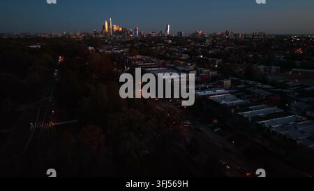 Bâtiments urbains en ville la nuit. Vue aérienne avec ligne d'horizon de gratte-ciel au loin. Plan d'établissement aérien en soirée, Philadelphie, Pennsylvanie. Banque D'Images