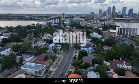 Scène de circulation sur la route au bord de la baie de la ville de Tampa au crépuscule. Plan aérien large. Skyline du centre-ville avec gratte-ciel au loin. Floride, États-Unis. Banque D'Images