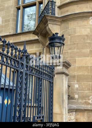 Détail d'un bâtiment historique en pierre avec une clôture en fer forgé et une lanterne. Détail d'un bâtiment historique européen en pierre présentant une clôture en fer forgé ornée, une Banque D'Images