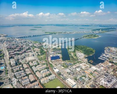 Vue aérienne à angle élevé de Rikers Island, le viaduc ferroviaire MTA New York City Subway A et le pont commémoratif des anciens combattants de Cross Bay s'étendant sur... Banque D'Images