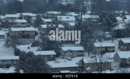 Jour gris et enneigé dans une banlieue américaine. Maisons situées sur une colline enneigée. Arbres sans feuilles dans une zone rurale. Plan aérien en zoom large, Ephrata, Pennsylvanie. Banque D'Images