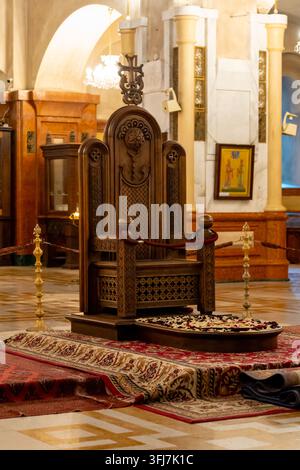 Un trône en bois richement décoré, présentant des sculptures détaillées et une croix proéminente, se dresse dans un cadre sacré d'église. Cathédrale de la Sainte Trinité, Sa Banque D'Images