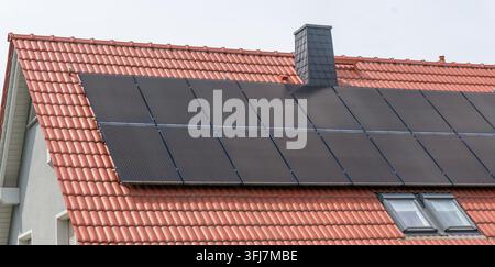 Panneaux solaires sur toit avec tuiles rouges traditionnelles Banque D'Images