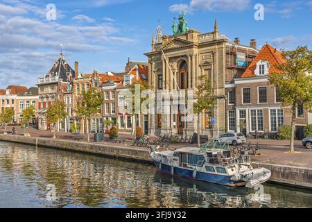 Haarlem, Pays-Bas – 16 août 2026. Le majestueux bâtiment du musée Teylers le long de la rivière Spaarne avec un bateau amarré, se reflétant dans l’eau lors d’une Banque D'Images