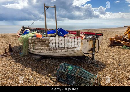 Ancien bateau de pêche en bois usé sur une plage de galets et de gravier à Aldeburgh dans le Suffolk, en Angleterre. Banque D'Images