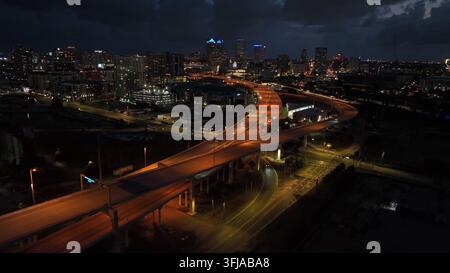 Plan d'établissement aérien des autoroutes surélevées éclairées à Tampa la nuit. Voitures roulant sur la rue menant au centre-ville de la ville en Floride. Éclairage c Banque D'Images