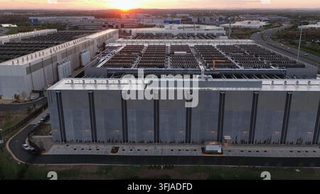 Grand campus de centre de données à Ashburn, Virginie, États-Unis au coucher du soleil montrant des bâtiments de serveurs étendus, des systèmes de refroidissement sur le toit et une infrastructure cloud moderne Banque D'Images