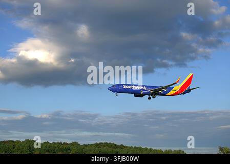 Avion de ligne passager Southwest Airlines Boeing 737 volant sous des nuages orageux dramatiques. Banque D'Images