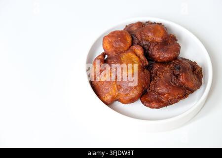 Délicieuses bananes frites croustillantes avec graines de sésame servies sur une assiette blanche Banque D'Images