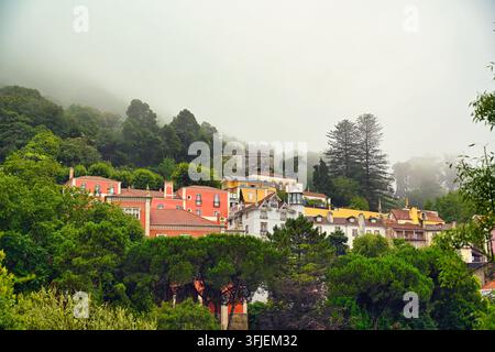 Une magnifique prise de paysage en grand angle capturant la ville historique pittoresque de Sintra nichée parmi des forêts luxuriantes sur une colline, partiellement couverte Banque D'Images