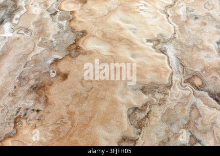 Un gros plan abstrait de motifs complexes ondulés par le vent et de textures minérales fines sur les sols de sable blanc des Lencois Maranhenses, au Brésil. Banque D'Images