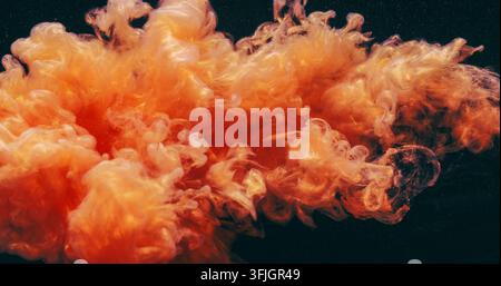 Éclaboussure de brume sous l'eau goutte d'encre nuage orange fluide Banque D'Images