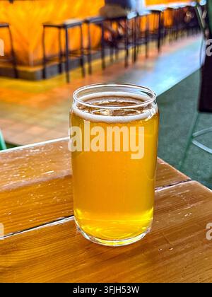 Pinte de bière ambrée sur une table dans un verre en forme de pot Mason. Pas de personnes. Banque D'Images