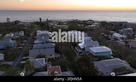Maisons et appartements de luxe du quartier de Longboat Key au coucher du soleil. Survol aérien par le dessus. Bâtiments haut de gamme avec vue sur la baie en Floride. C Banque D'Images