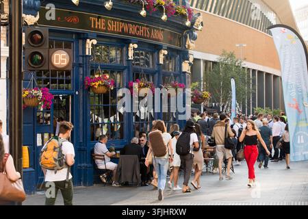 Les piétons traversent près du pub Shipwrights Arms à Londres, passant devant un festival de nourriture et des places de siège en plein air alors que le signal de traversée indique 5 secondes Banque D'Images