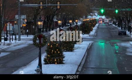 Vue aérienne de sapins de Noël et de couronnes bordant la rue principale d'une petite ville américaine. Magnifique chute de neige pittoresque lors d'un Noël blanc. Longue Banque D'Images
