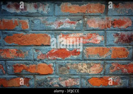 Texture de mur en briques rouges patinées avec maçonnerie rugueuse vieillie, mortier gris et fond de surface grunge. Banque D'Images