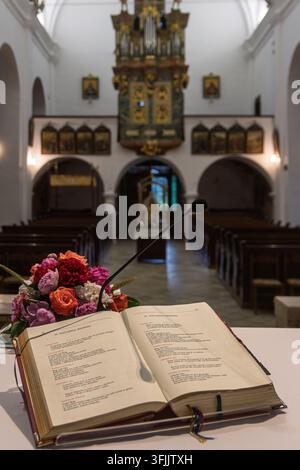 Livre liturgique chrétien ouvert sur une chaire d'autel à l'intérieur d'une église catholique traditionnelle Banque D'Images
