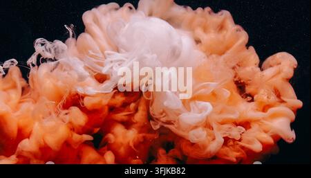 Éclaboussure de brume sous l'eau goutte d'encre nuage orange fluide Banque D'Images