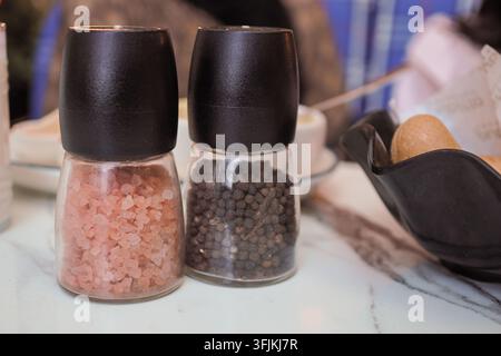 Salières et poivrières sur une table dans un cadre de restaurant Banque D'Images