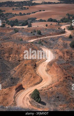 Une route de terre serpentine serpente à travers le terrain accidenté de Rambla Barrachina à Teruel, mettant en valeur la beauté naturelle et la solitude, Teruel, Sapin Banque D'Images