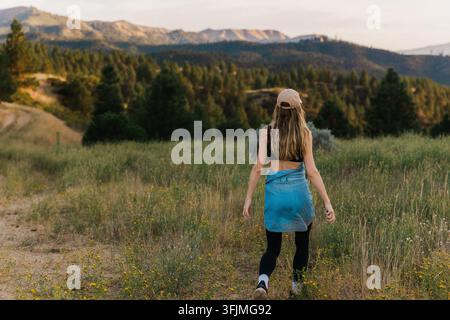 Femme marchant sur un sentier naturel à travers un paysage montagneux Banque D'Images
