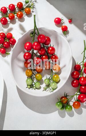 Des tomates cerises colorées mûrissant sur la vigne dans un bol Banque D'Images