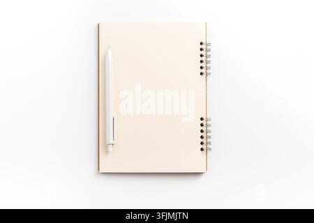 Vue de dessus d'un modèle de bloc-notes à spirale vierge avec stylo sur fond blanc avec espace de copie Banque D'Images