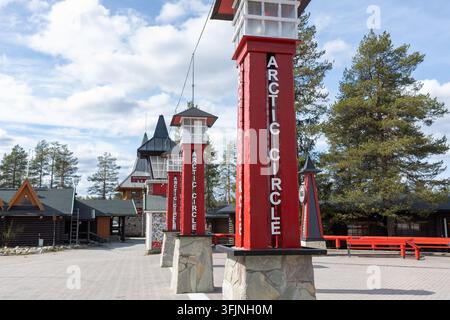 Rovaniemi, Finlande – 15 mai 2026 : Des poteaux en bois rouge marquant le cercle polaire dans le village du Père Noël, Rovaniemi, Laponie, Finlande, avec traditi Banque D'Images