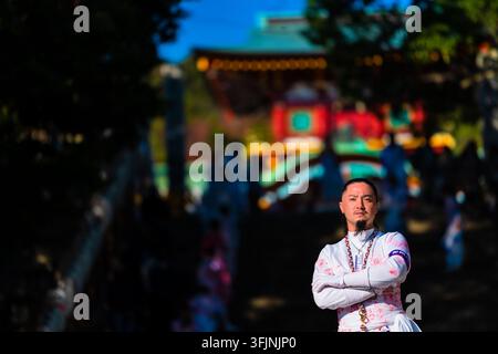 Un homme japonais vêtu de vêtements blancs cérémoniels se tient devant le sanctuaire Hofu Tenmangu pendant le festival Gojinko à Hofu, au Japon. Banque D'Images
