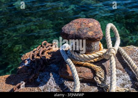 Close-up d'un bollard rouillé et d'épaisses cordes d'amarrage au port de La Isleta dans le parc naturel de Cabo de Gata-Níjar, Almeria, Andalousie, Espagne. Banque D'Images