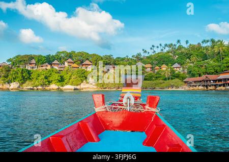 Vue depuis un bateau à longue queue thaïlandais traditionnel près d'une côte tropicale avec des resorts en colline et des palmiers sur Koh Tao, Thaïlande. Transport insulaire Banque D'Images