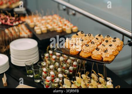 Table de catering avec divers apéritifs gourmands et pâtisseries salées Banque D'Images