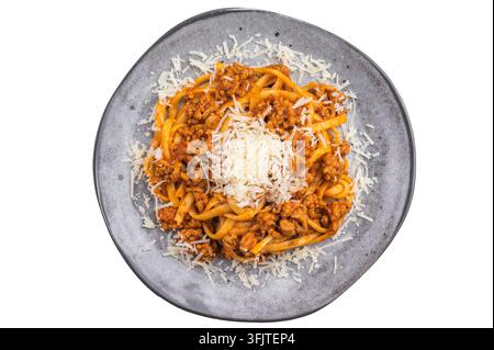 Pâtes classiques bolognaises avec ragu de viande riche et parmesan râpé sur une assiette grise sur fond blanc, plat italien copieux Banque D'Images