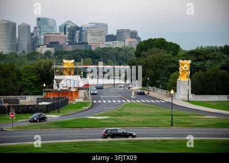 Statue des Arts de la Paix près de Rosslyn Skyline à Washington DC | WASHINGTON — Le groupe équestre des Arts de la Paix se dresse à l’entrée du Rock Creek and Potomac Parkway vers le pont commémoratif d’Arlington dans le West Potomac Park, avec la ligne d’horizon de Rosslyn, en Virginie, en arrière-plan, le jeudi 17 septembre 2026. Les groupes en bronze doré flanquent le Lincoln Memorial Circle et sont gérés par le National Park Service. James Earle Fraser a modelé Music and Harvest et Aspiration and Literature, coulés en bronze et dorés en Italie en 1949-50 en cadeau du gouvernement italien, et dédiés par le président Harry S. Truman en septembre. Banque D'Images