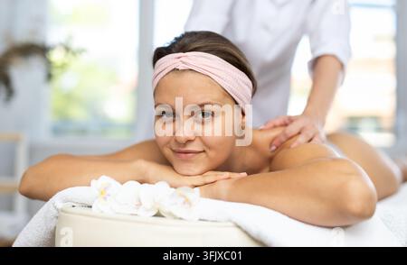 Jeune femme cliente recevant un massage du dos et des épaules, gros plan dans la salle de massage Banque D'Images