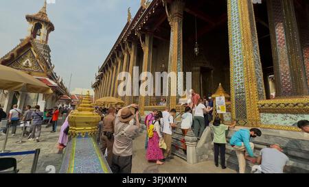 BANGKOK, THAÏLANDE - 12 MARS 2026 : Touristes visitant le bâtiment du temple doré orné de Wat Phra Kaew à Bangkok, Thaïlande. Banque D'Images