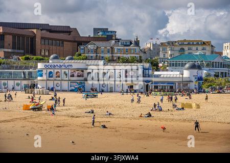 Vue panoramique ensoleillée du bâtiment de l'aquarium Oceanarium et des visiteurs sur la plage de sable de Bournemouth, Dorset, Angleterre, Royaume-Uni Banque D'Images