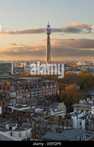 Un coucher de soleil doré baigne la ligne d'horizon de Fitzrovia à Londres et l'emblématique tour BT d'une lumière chaude, mettant en valeur le feuillage automnal vibrant. Banque D'Images