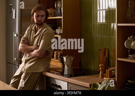 Homme attendant que le café du matin soit préparé dans la cuisine Banque D'Images