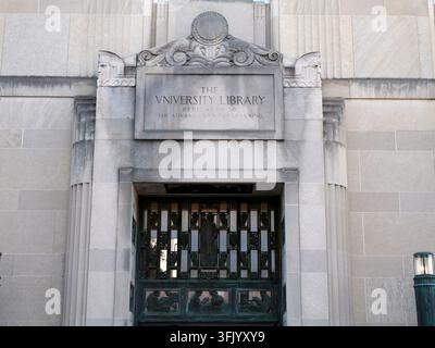 Entrée majestueuse d'un bâtiment de bibliothèque universitaire présentant une façade en pierre sculptée, des portes en fer décorées et une inscription dédiée au progrès Banque D'Images