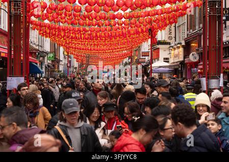 Des foules se rassemblent sous des lanternes rouges sur Gerrard Street dans le quartier chinois de Londres pour célébrer le Nouvel An lunaire. Banque D'Images