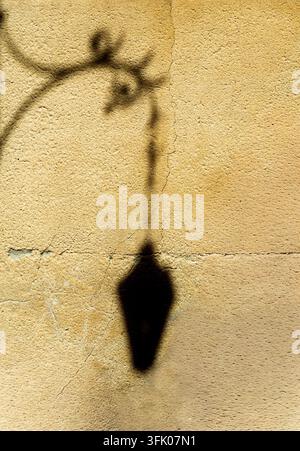 Silhouette sombre d'un lampadaire sur un mur Banque D'Images