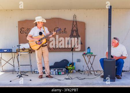 Arkansas, États-Unis, 07 AVR 2024 – Un musicien joue d’une guitare acoustique sur une scène sous un abri en bois au parc Eiffel. Banque D'Images