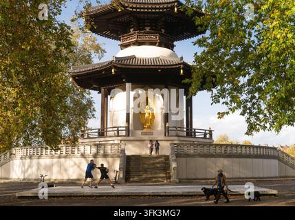 Des gens font de l'exercice et promènent leurs chiens à la Pagode de la Paix de Londres dans le Battersea Park, un monument bouddhiste dédié à la paix mondiale. Banque D'Images