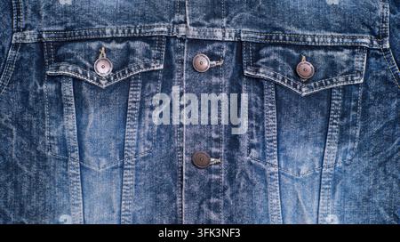 veste en jean bleu avec poches avant, boutons en métal, coutures verticales et détail textile indigo usé. Banque D'Images