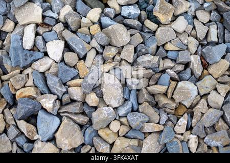 Texture en gros plan de pierres de gravier mélangées gris et beige. Vue en gros plan de pierres de gravier mélangées gris, beige et bleu formant une formation rocheuse naturelle rugueuse Banque D'Images