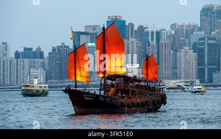 La célèbre jonque touristique à voile rouge naviguant le long du port de Victoria, Hong Kong, Chine. Banque D'Images